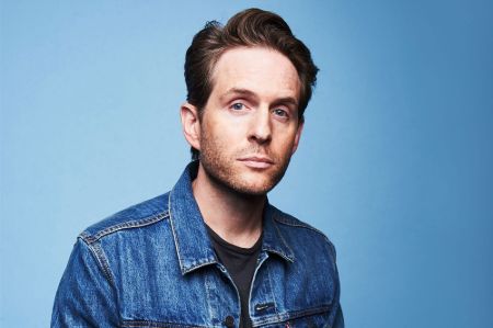 Actor Glenn Howerton in a blue jeans jacket poses for a picture.
